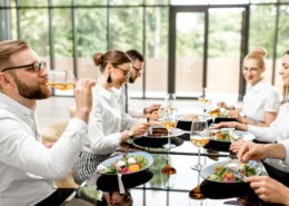 Auf dem Bild sind Geschäftsleute zu sehen, die gemeinsam einen köstlichen und gesunden Mittagstisch genießen. Sie sitzen an einem eleganten Tisch in einem Restaurant.