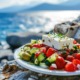 Mediterrane Ernährung: Griechischer Salat mit Meereshintergrund