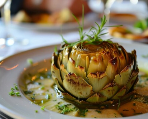 Perfekt gegarte Artischocke, liebevoll serviert mit frischer Kräuterbutter und einem Hauch Zitronensaft – ein wahres Fest für die Sinne und den Gaumen.