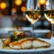 Food-Pairing: Ein Teller mit perfekt gebratenem Fischfilet, kombiniert mit gerösteten Kartoffeln und frischen Kräutern, harmonisch abgestimmt mit zwei Gläsern Weißwein in einer eleganten Restaurantatmosphäre.