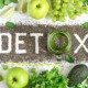 Detox-Bild mit grünen Äpfeln, Trauben, Avocado, Limetten und Chiasamen, die das Wort 'Detox' formen – ein inspirierendes Arrangement für gesunde Ernährung und Entgiftung.