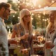 Vier junge Erwachsene genießen ein Sommerfest im Freien in München, lachen und stoßen mit Getränken an, im Hintergrund ein stilvoll dekoriertes Catering-Buffet mit Sonnenschirmen und Lichterketten bei warmem Abendlicht.