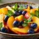 Geschnittene Nektarinen in einem Gourmet-Obstsalat mit Blaubeeren und Minzblättern, serviert auf einem eleganten Keramikteller, weiches natürliches Licht