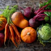 beta_carotin _Lebensmittel Wunderschön arrangiertes Ensemble aus orangefarbenem Gemüse (Karotten, Hokkaido-Kürbis, roter Paprika, Feldsalat) neben grünen Blattgemüsen (Spinat, Grünkohl); starker Farbkontrast, natürliches Gegenlicht, hochwertige Food-Fotografie