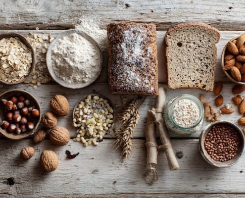 Magnesiumreiche Lebensmittel auf einem hellen Holztisch, Haferflocken, Mandeln, Erdnüsse, Hülsenfrüchte, Vollkornbrot, natürliche Farben, cleanes Food-Styling, Tageslicht, hochwertige Ernährungsfotografie, ruhig, gesund, modern,
