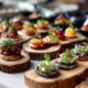 Modernes Business-Event mit Bio-Fingerfood, Flying Catering Stil, kleine herzhafte Häppchen auf Holz- und Keramikplatten, vegane und vegetarische Snacks, nachhaltige Präsentation, helle Atmosphäre, dezenter Hintergrund, professionelle Food Fotografie, natürlicher Look