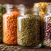 Nahaufnahme von Hülsenfrüchten, Linsen, Kichererbsen, Erbsen in Glasgefäßen, pflanzliche Eiweißquellen, vegan, nachhaltig, ruhiger Hintergrund, natürliche Texturen, warmes Licht, Editorial Food Photography, ultra realistic, high detail