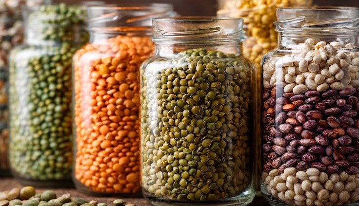 Nahaufnahme von Hülsenfrüchten, Linsen, Kichererbsen, Erbsen in Glasgefäßen, pflanzliche Eiweißquellen, vegan, nachhaltig, ruhiger Hintergrund, natürliche Texturen, warmes Licht, Editorial Food Photography, ultra realistic, high detail